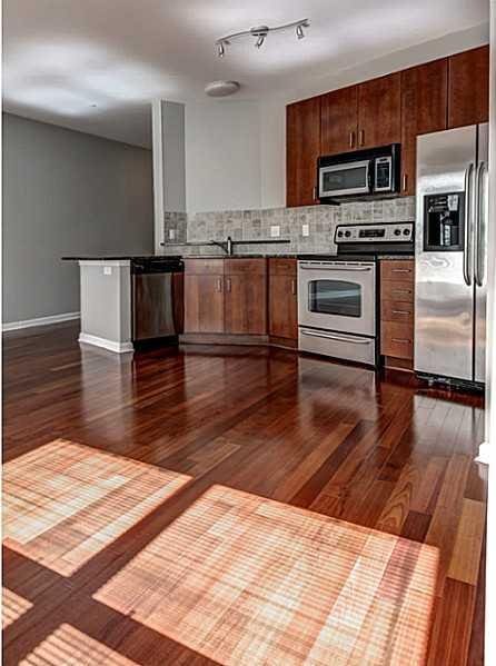 kitchen featuring dark hardwood / wood-style flooring, appliances with stainless steel finishes, and tasteful backsplash