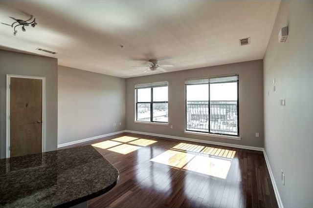 spare room featuring ceiling fan and dark hardwood / wood-style floors