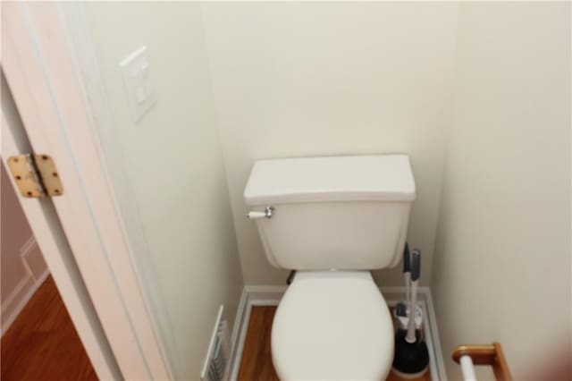 bathroom with hardwood / wood-style flooring and toilet