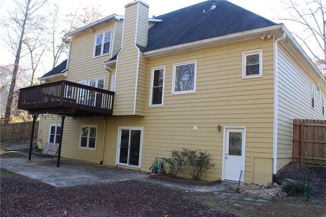 back of property with a deck and a patio