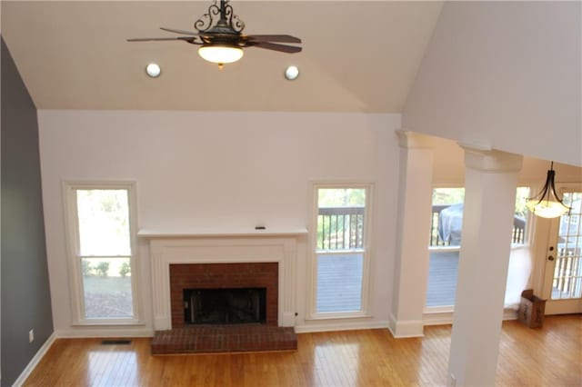 unfurnished living room featuring ceiling fan, light wood-type flooring, lofted ceiling, and a fireplace