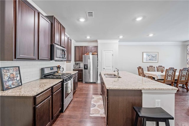 221 Irwell Path, Lawrenceville, GA 30044 - kitchen featuring appliances with stainless steel finishes, crown molding, a sink, a kitchen breakfast bar, and a kitchen island with sink