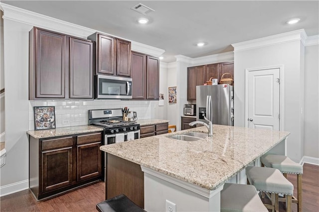221 Irwell Path, Lawrenceville, GA 30044 - kitchen with stainless steel appliances, a sink, a breakfast bar, baseboards, and ornamental molding