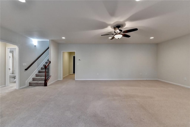 spare room with recessed lighting, light colored carpet, a ceiling fan, baseboards, and stairway