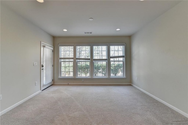 spare room with light carpet, recessed lighting, visible vents, and baseboards