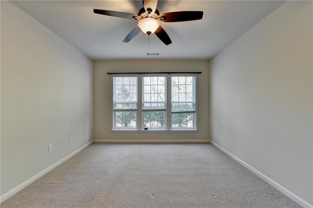 carpeted empty room featuring a ceiling fan, visible vents, and baseboards