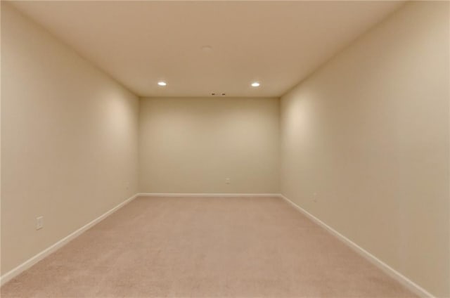 empty room featuring recessed lighting, baseboards, and light colored carpet