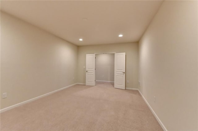 unfurnished bedroom featuring light carpet, baseboards, and recessed lighting