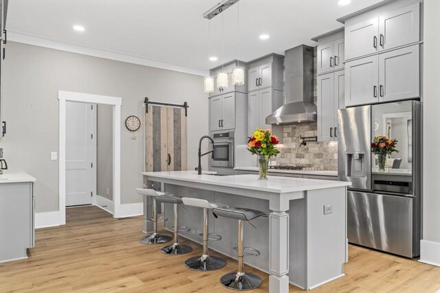 407 Estates View Dr, Acworth, GA 30101 - kitchen with stainless steel appliances, wall chimney range hood, a barn door, backsplash, and light countertops