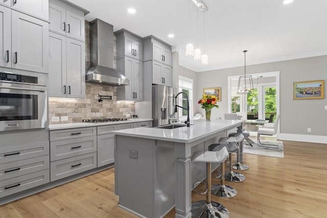 407 Estates View Dr, Acworth, GA 30101 - kitchen featuring appliances with stainless steel finishes, wall chimney range hood, gray cabinetry, light countertops, and a sink