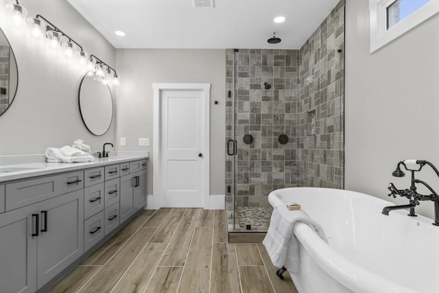 407 Estates View Dr, Acworth, GA 30101 - bathroom with a shower stall, a freestanding tub, double vanity, recessed lighting, and wood tiled floors