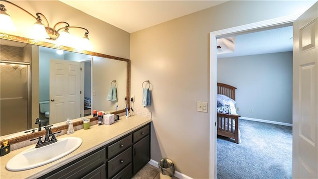 full bathroom with toilet, a shower with door, vanity, and baseboards