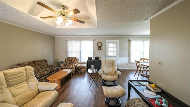 living room with dark wood finished floors, a textured ceiling, crown molding, and ceiling fan
