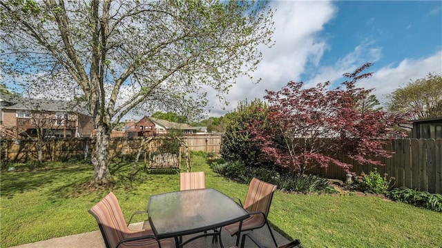 view of yard with a patio area, a fenced backyard, and outdoor dining space