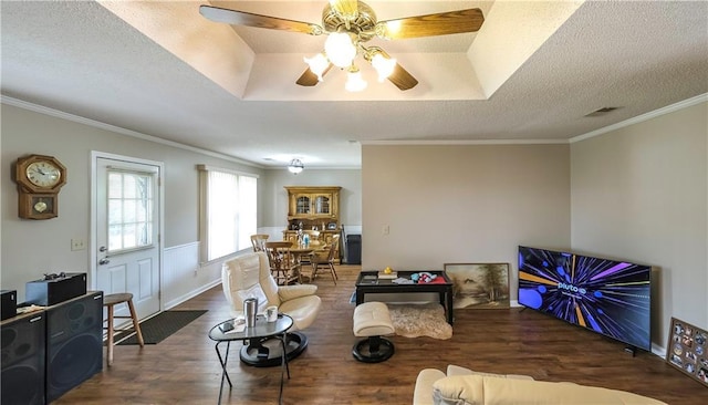 living room with a ceiling fan, wood finished floors, crown molding, and a textured ceiling