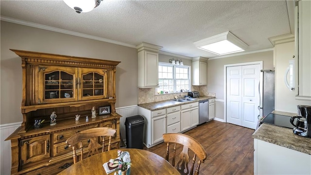 kitchen featuring dark wood finished floors, a textured ceiling, appliances with stainless steel finishes, and a sink