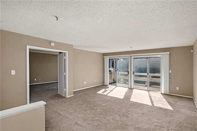 empty room with carpet and a textured ceiling