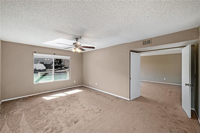 empty room featuring light colored carpet, a textured ceiling, and ceiling fan