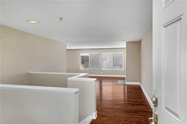 spare room with hardwood / wood-style floors, a notable chandelier, and a textured ceiling