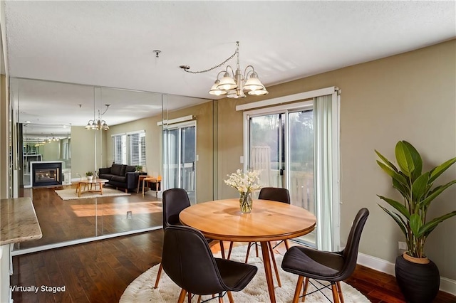 dining area with an inviting chandelier, a healthy amount of sunlight, and hardwood / wood-style flooring