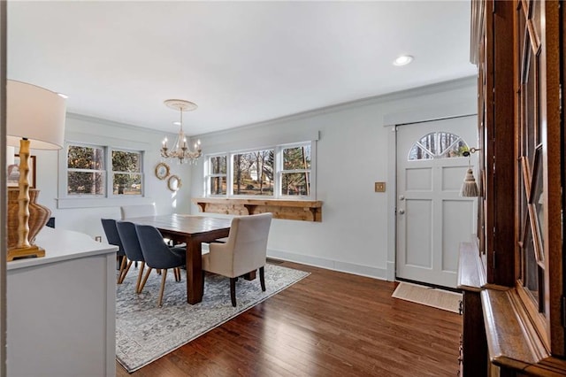 dining space with baseboards, dark wood-type flooring, crown molding, a notable chandelier, and recessed lighting