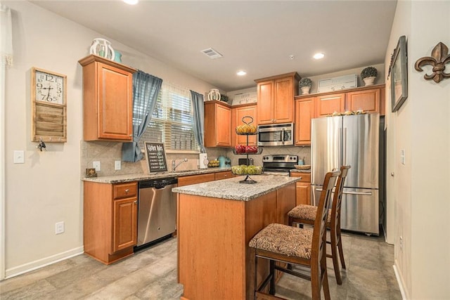 2294 Spicy Pine Ln, Lawrenceville, GA 30044 - kitchen featuring appliances with stainless steel finishes, a kitchen island, decorative backsplash, a kitchen breakfast bar, and recessed lighting