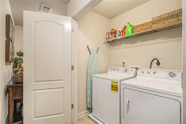2294 Spicy Pine Ln, Lawrenceville, GA 30044 - laundry area with washing machine and dryer, light tile patterned flooring, and baseboards