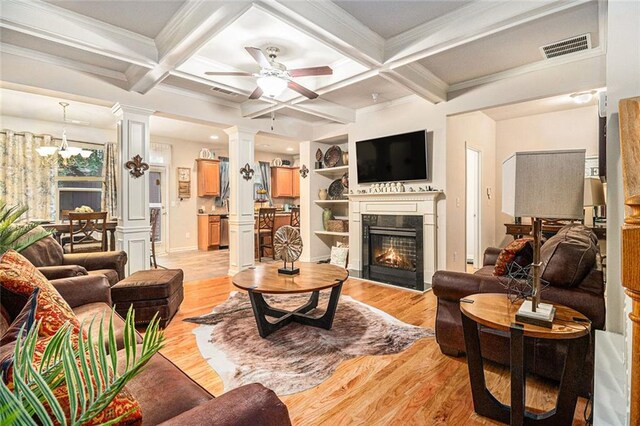 2294 Spicy Pine Ln, Lawrenceville, GA 30044 - living room featuring ornate columns, light wood-type flooring, ceiling fan, a premium fireplace, and coffered ceiling