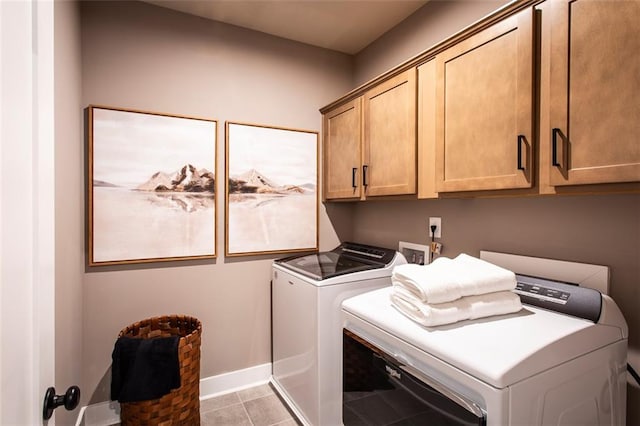 washroom with light tile patterned flooring, independent washer and dryer, and cabinets