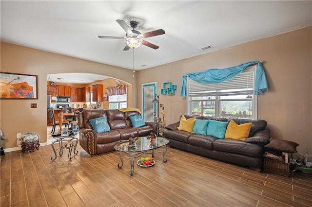 living room with light wood-type flooring and ceiling fan