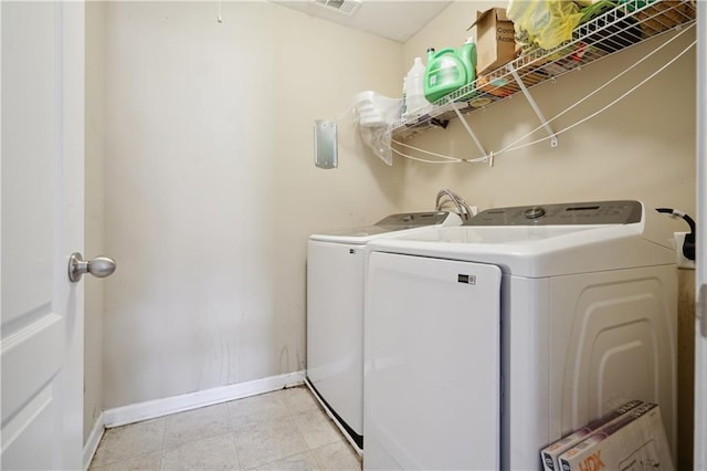 laundry room with light tile patterned floors and separate washer and dryer