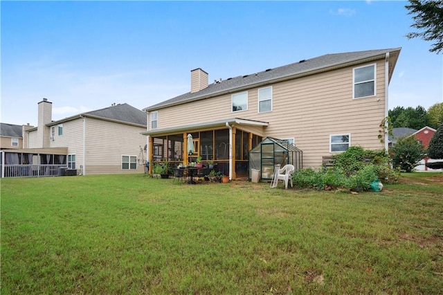 rear view of property featuring a lawn and a sunroom