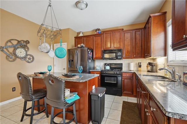 kitchen with sink, hanging light fixtures, a kitchen island, backsplash, and black appliances