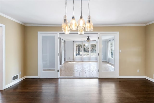 unfurnished dining area with crown molding, visible vents, and wood finished floors