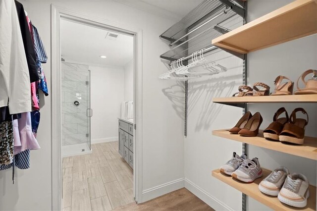 walk in closet featuring light hardwood / wood-style flooring