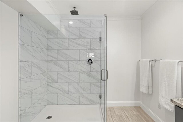 bathroom with walk in shower, crown molding, hardwood / wood-style flooring, and vanity