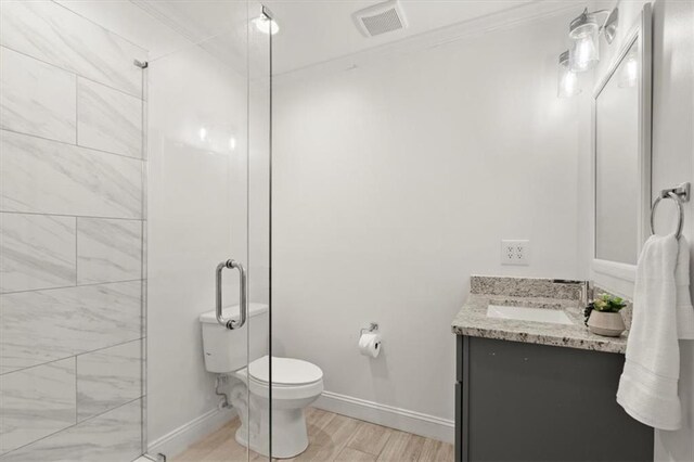 bathroom featuring vanity, toilet, ornamental molding, an enclosed shower, and hardwood / wood-style floors