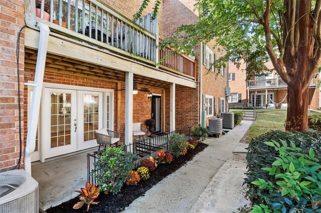 view of patio featuring french doors, a balcony, and central AC unit