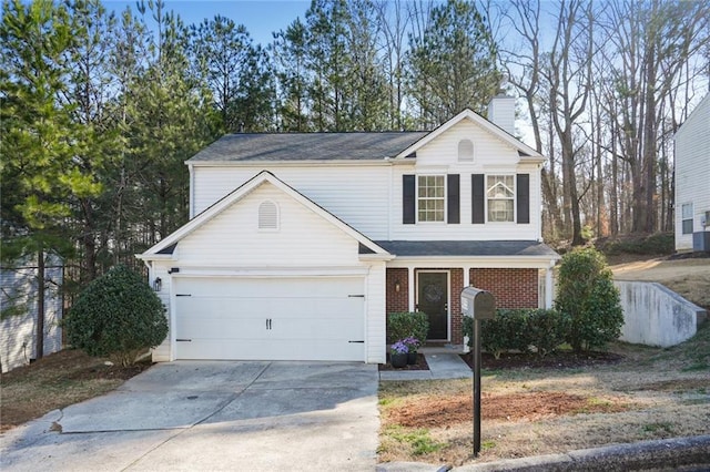 traditional-style home with a garage, driveway, a chimney, and brick siding