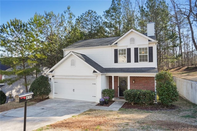 traditional-style home with concrete driveway, a chimney, an attached garage, fence, and brick siding