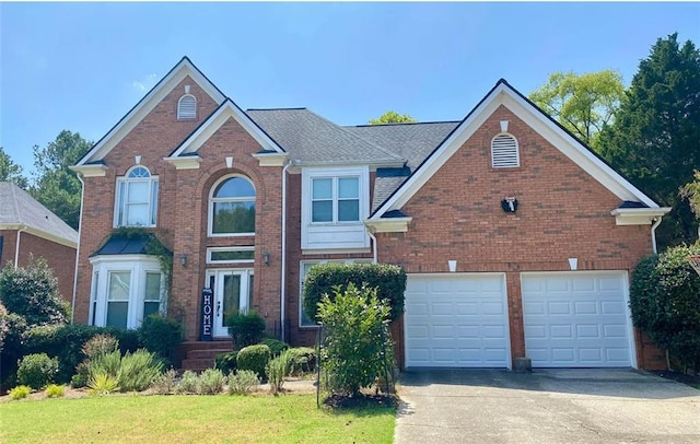 view of front of property with a garage, brick siding, and driveway