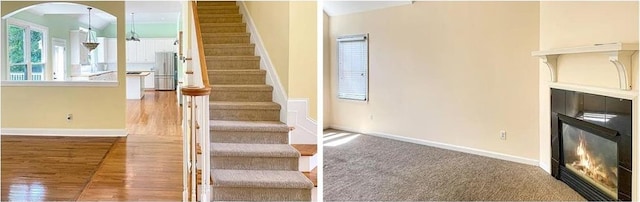 stairway featuring baseboards, arched walkways, wood finished floors, and a glass covered fireplace