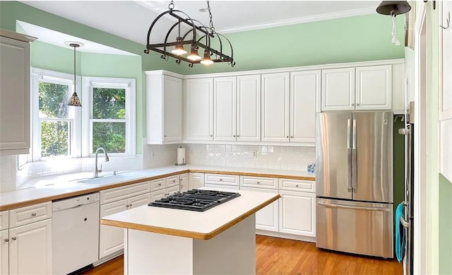 kitchen featuring white cabinets, dishwasher, freestanding refrigerator, a sink, and black gas stovetop