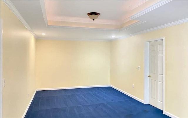 spare room with baseboards, a raised ceiling, and crown molding