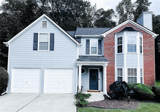 traditional-style home with brick siding, a chimney, a shingled roof, an attached garage, and driveway