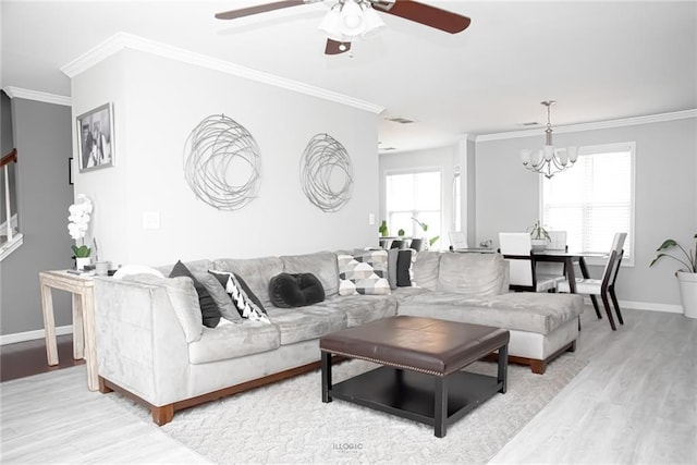 living room featuring baseboards, ornamental molding, ceiling fan with notable chandelier, and light wood-style floors