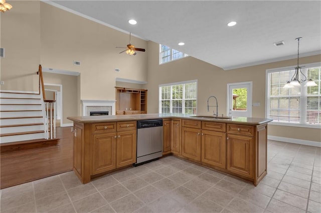 102 Plantation Dr, Lagrange, GA 30277 - kitchen featuring stainless steel dishwasher, crown molding, a ceiling fan, brown cabinets, and a fireplace