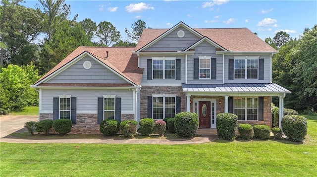 102 Plantation Dr, Lagrange, GA 30277 - view of front facade featuring stone siding, a front yard, a standing seam roof, a shingled roof, and a metal roof
