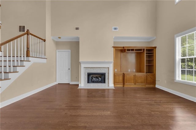 102 Plantation Dr, Lagrange, GA 30277 - unfurnished living room featuring a towering ceiling, wood finished floors, a high end fireplace, and stairs