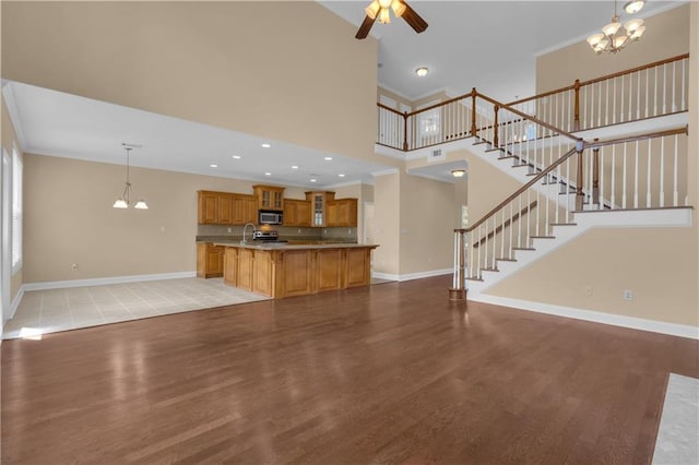 102 Plantation Dr, Lagrange, GA 30277 - unfurnished living room with light wood finished floors, a chandelier, ceiling fan, a towering ceiling, and stairs